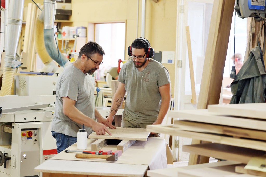 Artisan français fabriquant un meuble en bois massif sur mesure dans l'atelier Flip Design à Gaillac.